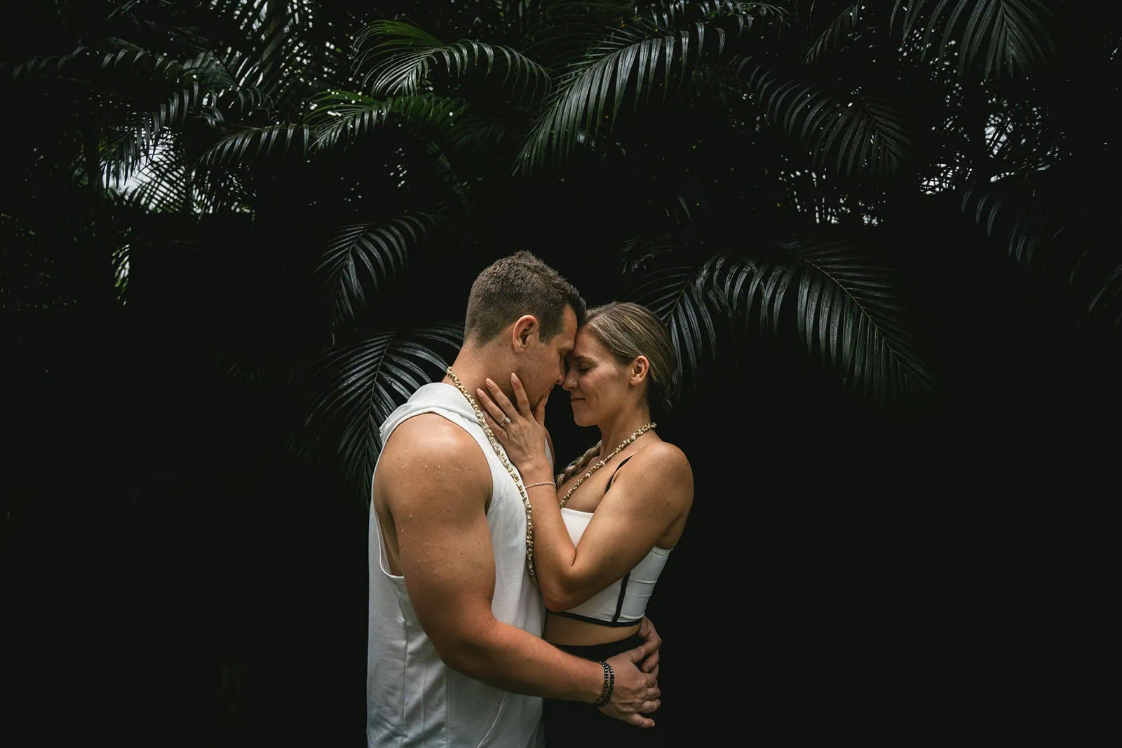 Couple's embrace in a lush firest in French Polynesia