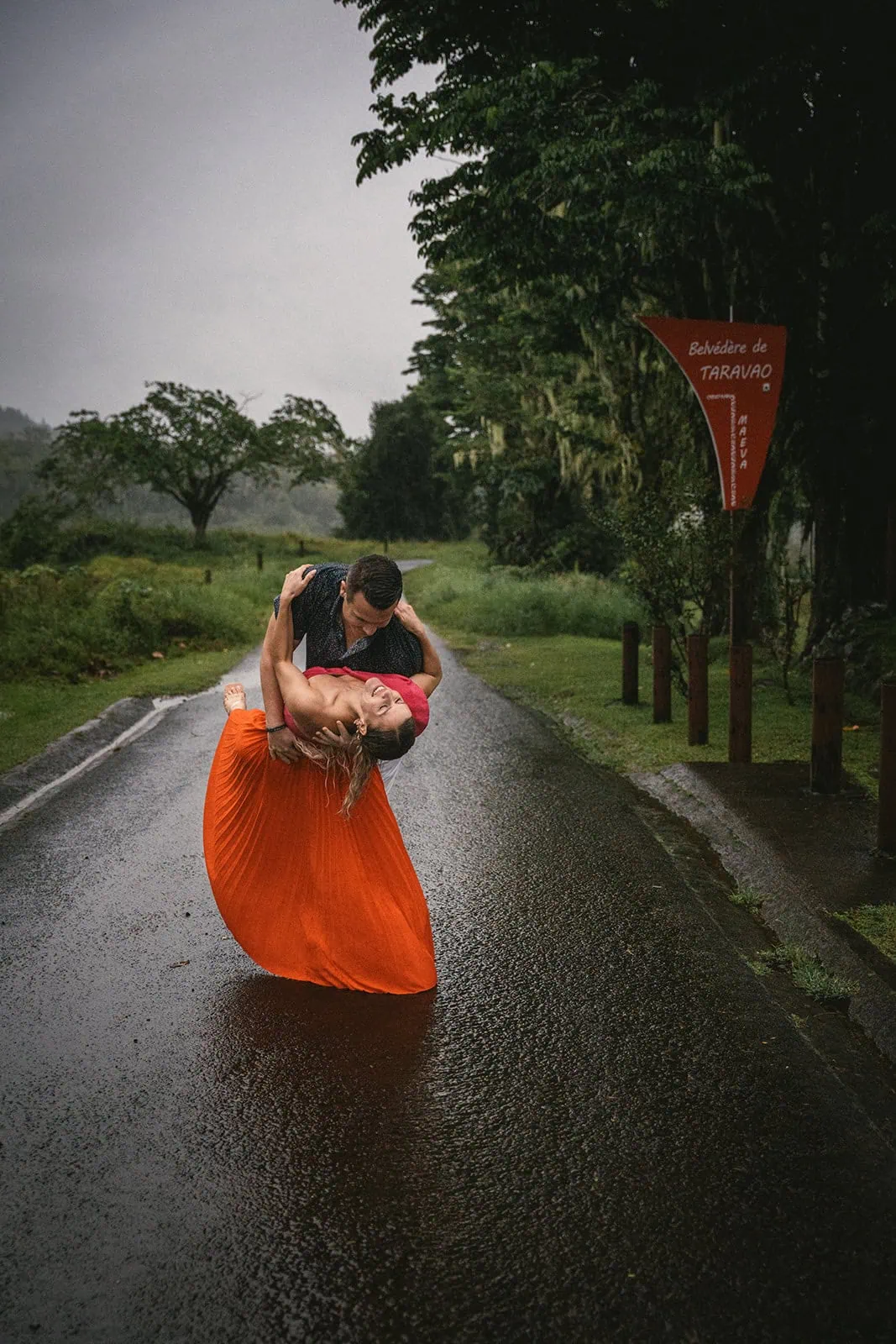 Newlyweds dancing in the rain, adding a magical touch to their French Polynesia elopement