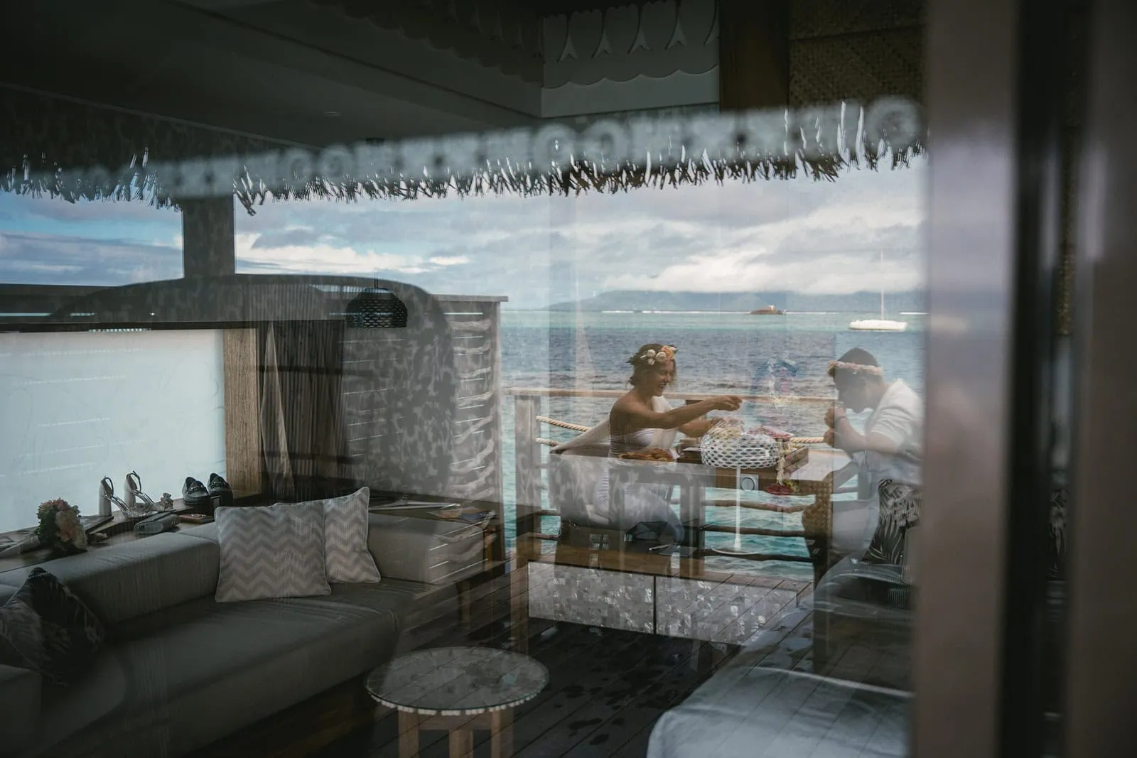 Newlyweds enjoying a relaxing dinner by the sea in French Polynesia.