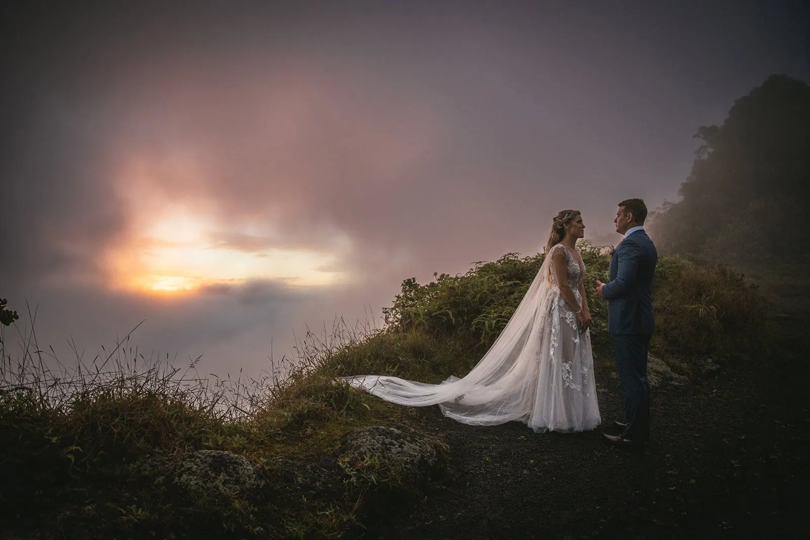 Groom placing the ring on the bride’s finger, in a scenic backdrop in French Polynesia