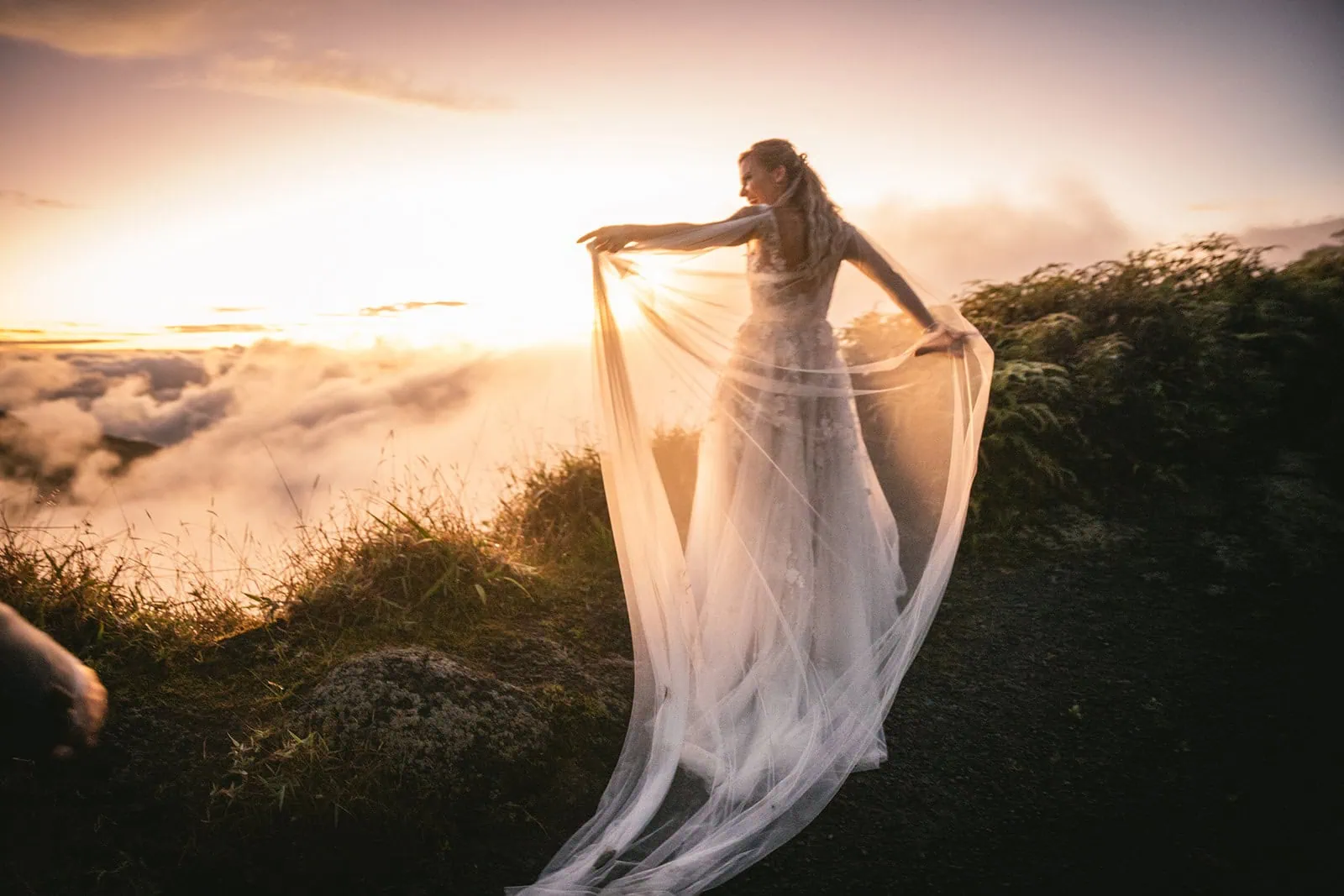 Bride twirling her flowing dress on a French Polynesia beach at golden hour