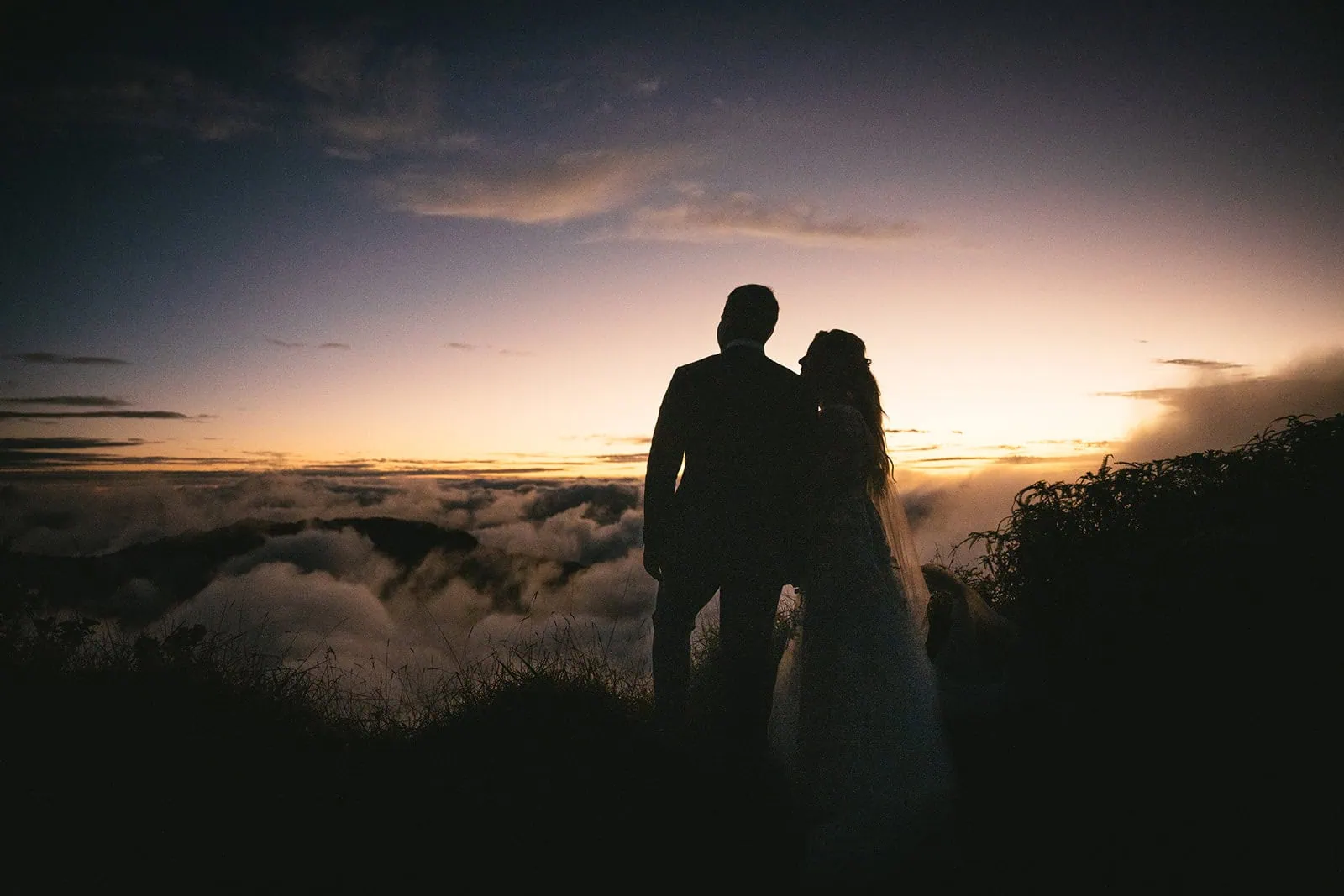 Bride and groom's silhouette against the sunset in French Polynesia