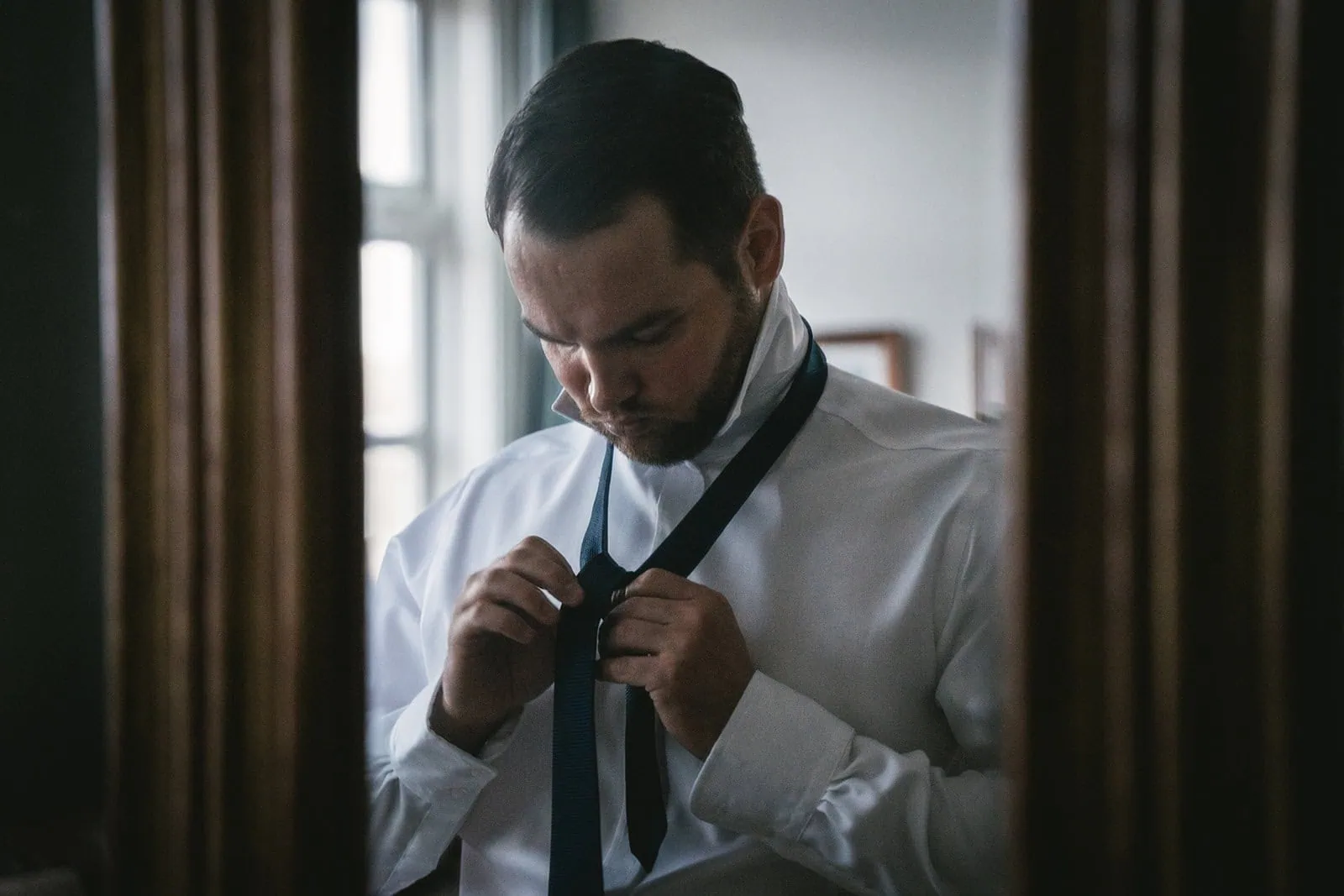 Groom putting his tie during an Iceland elopement