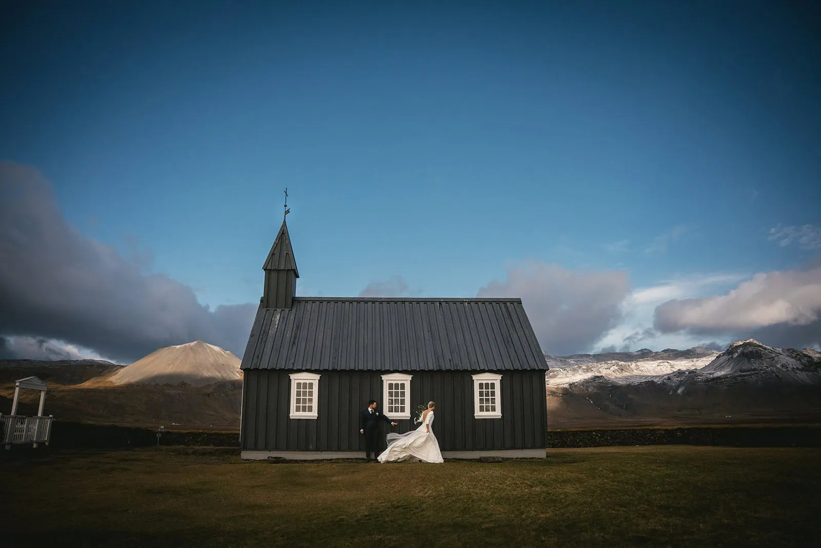 Joyful elopement scene with a couple in Iceland near a black church