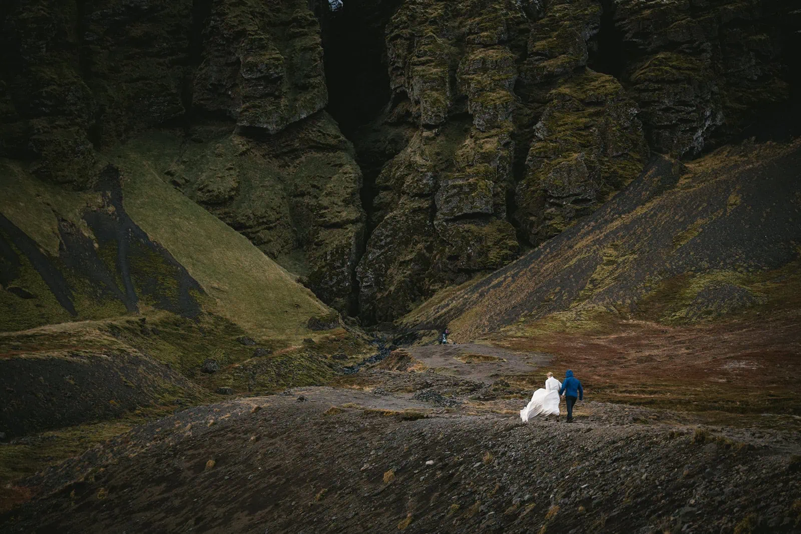 Bride and groom walking through a misty Icelandic landscape post-elopement