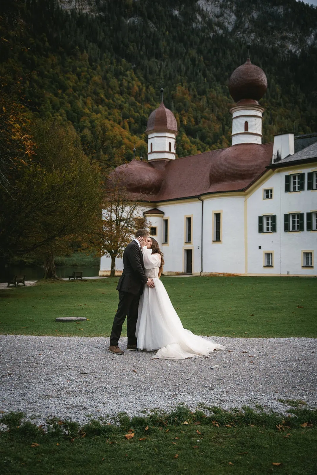 Newlyweds sharing a romantic embrace in front of a typic German house
