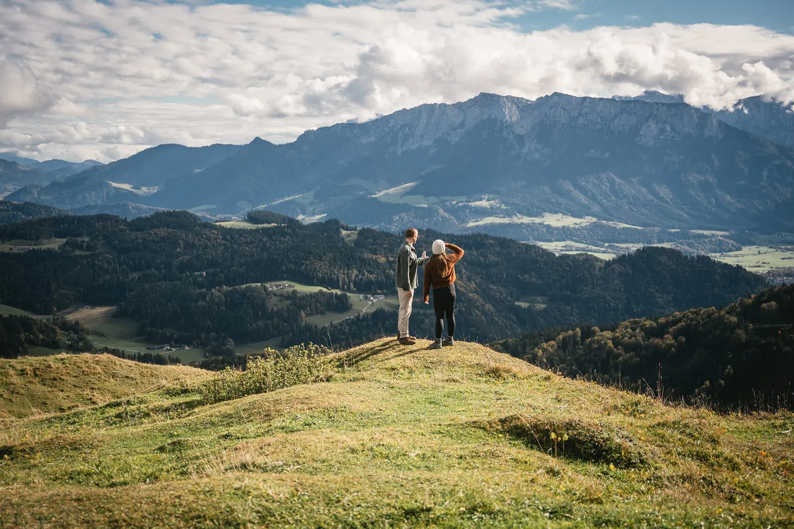 Newlyweds pausing on a scenic overlook, framed by the natural beauty of Austria