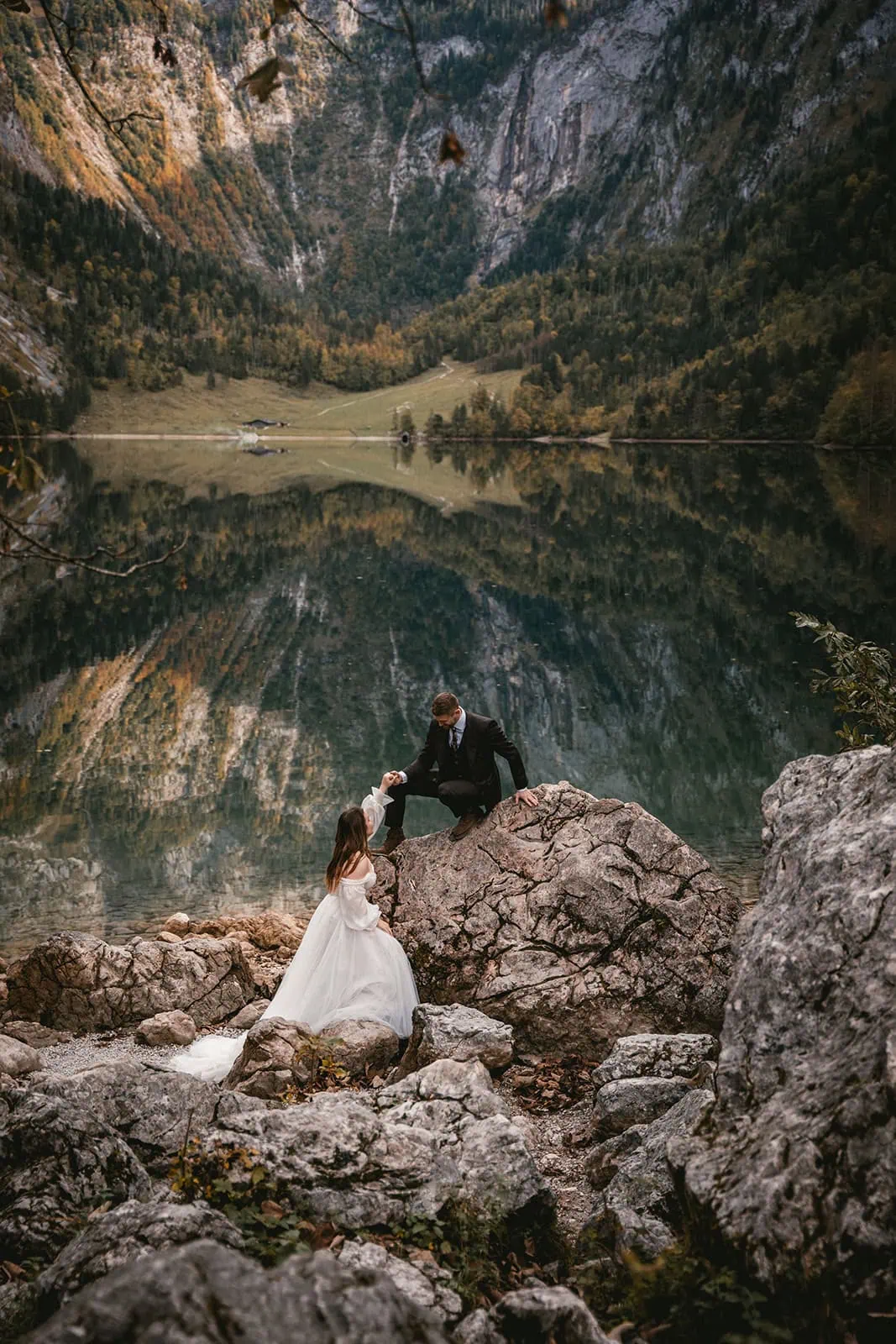 Groom guiding bride near a serene lake, adventurous Germany elopement