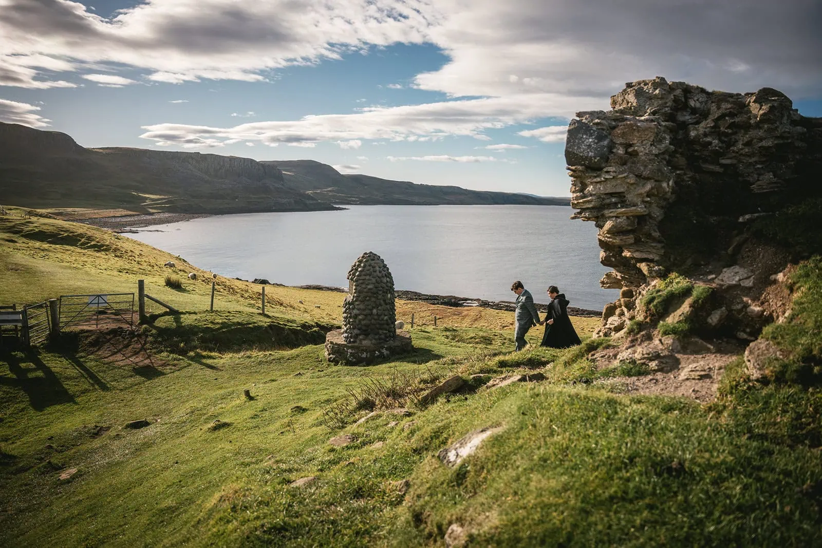 Bride and groom walking through a serene field in Skye, a quintessential Scotland elopement scene