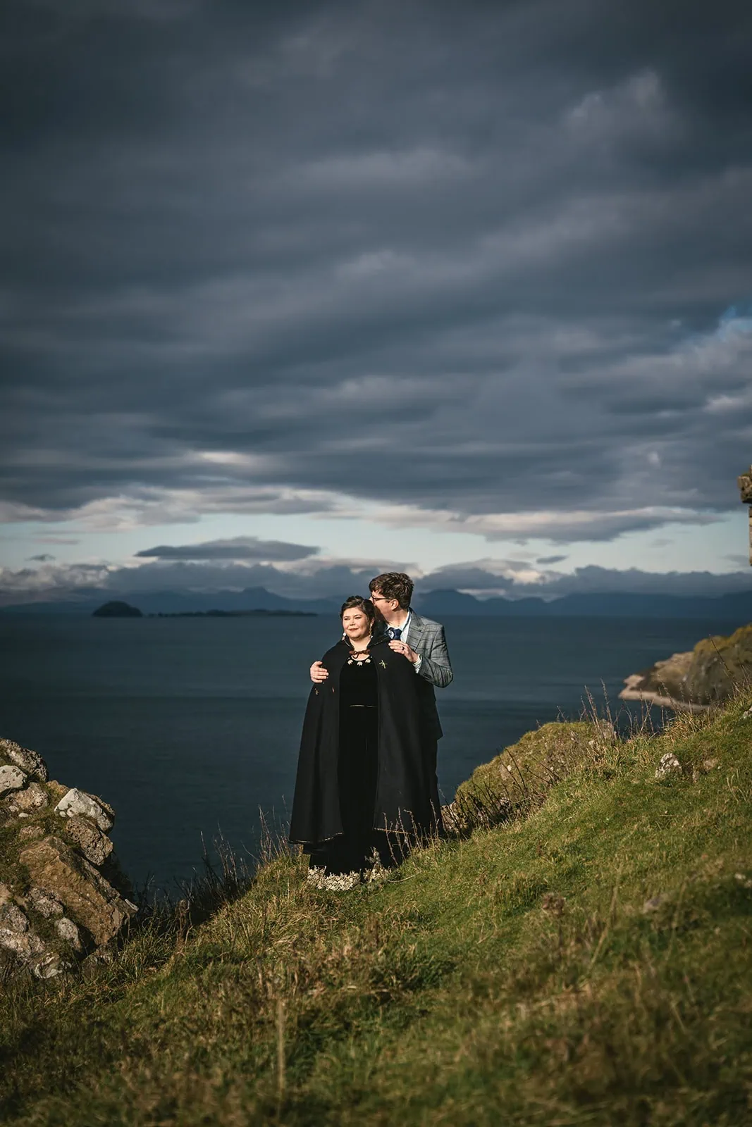 Newlyweds sharing a moment under the vast Skye skies