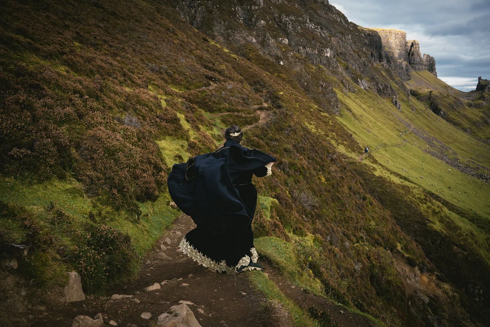 Bride walking through a lush Skye meadow, a serene moment in their Scotland elopement