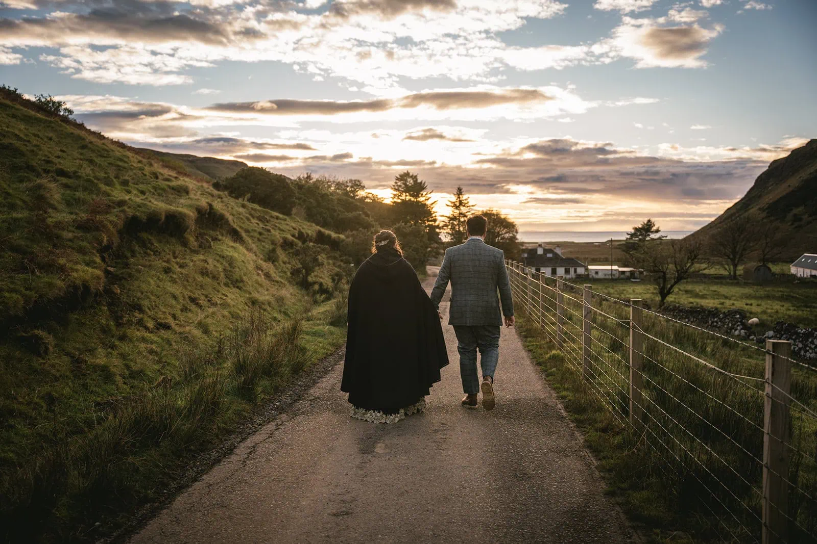 Skye elopement: Couple walking hand-in-hand along a secluded path at sunset