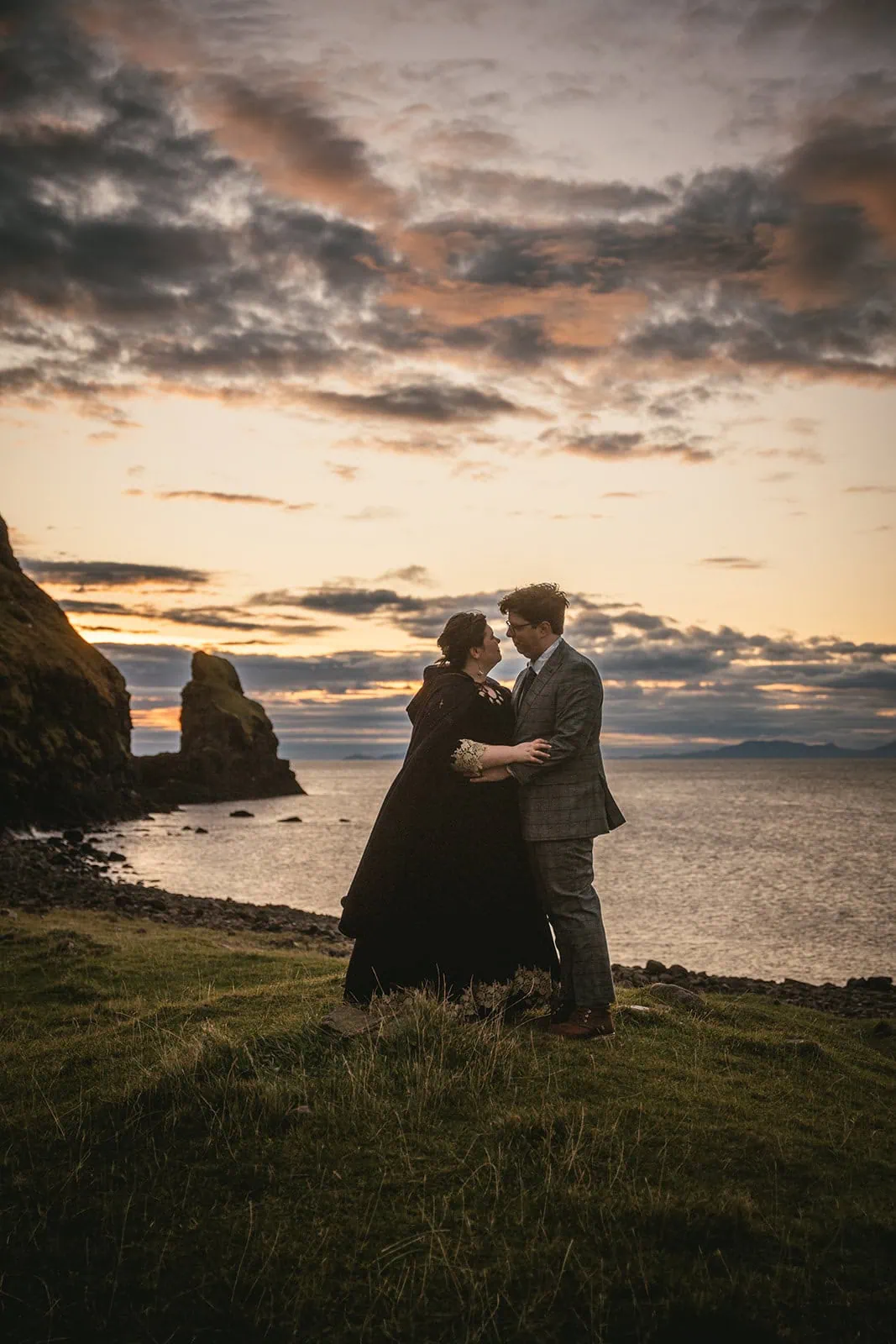 Couple's silhouette against the setting sun over Skye’s coastline