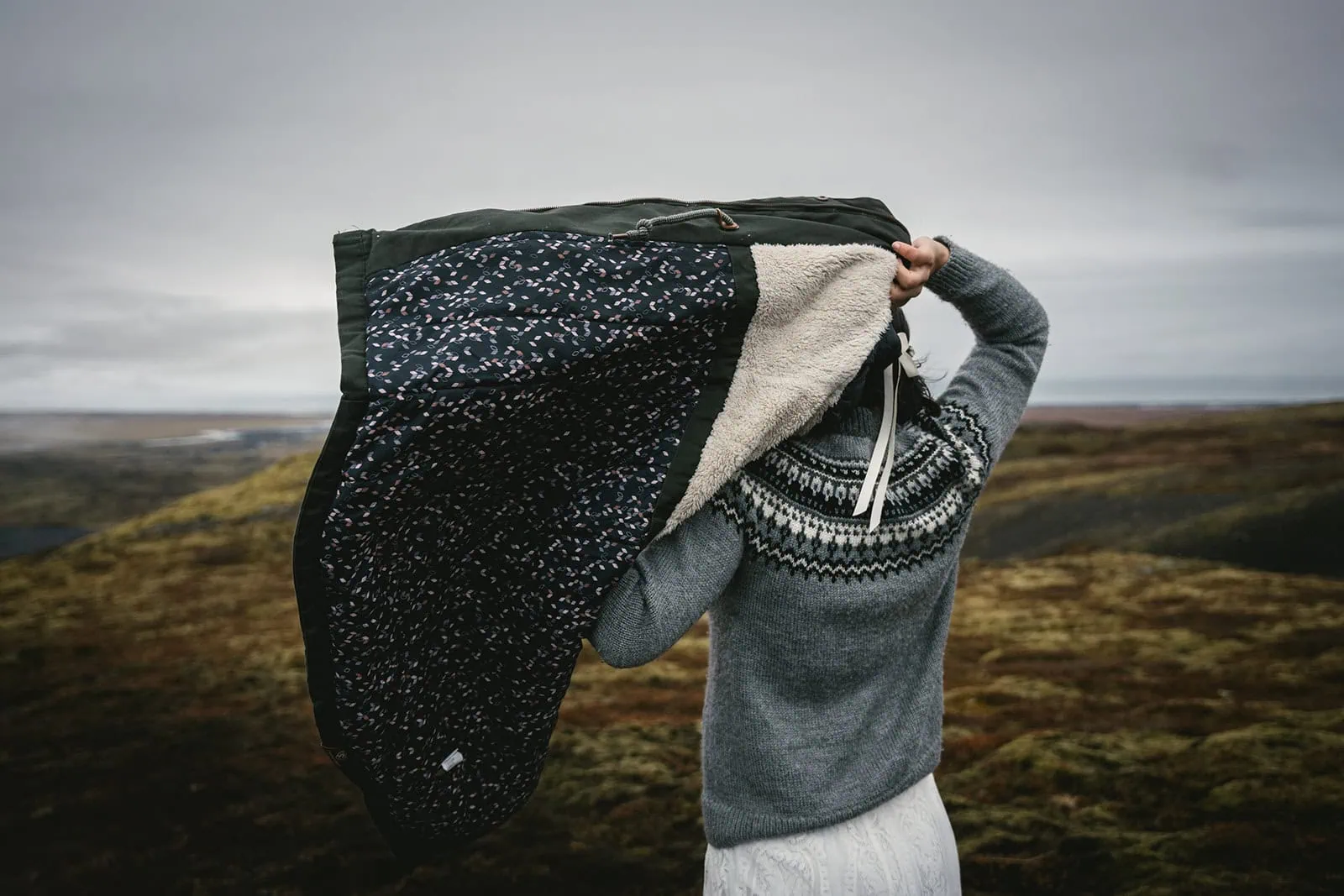 Bride’s coat catching the wind at the Mulafjulfur elopement