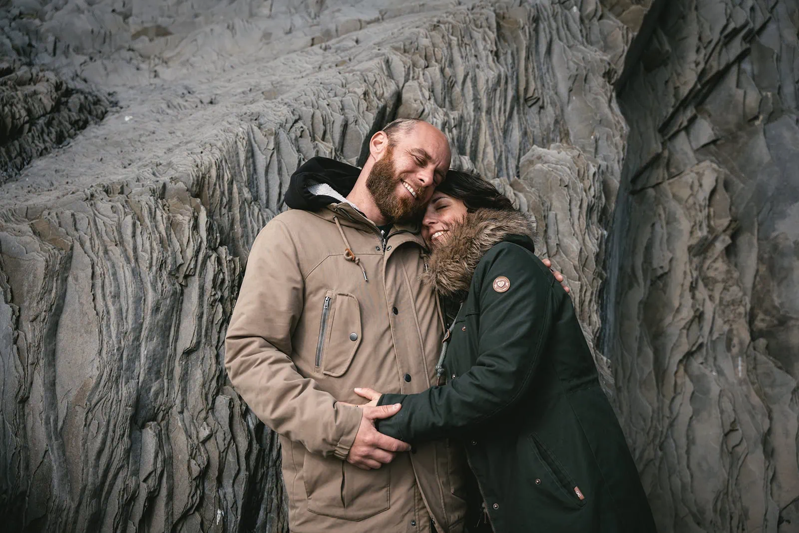 Bride and groom embracing with Iceland’s rugged landscape as a backdrop during their elopement