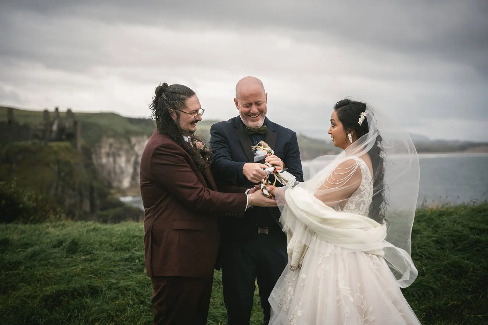 Dunluce Castle elopement : the couple's hands are linked during the ceremony to represent their commitment