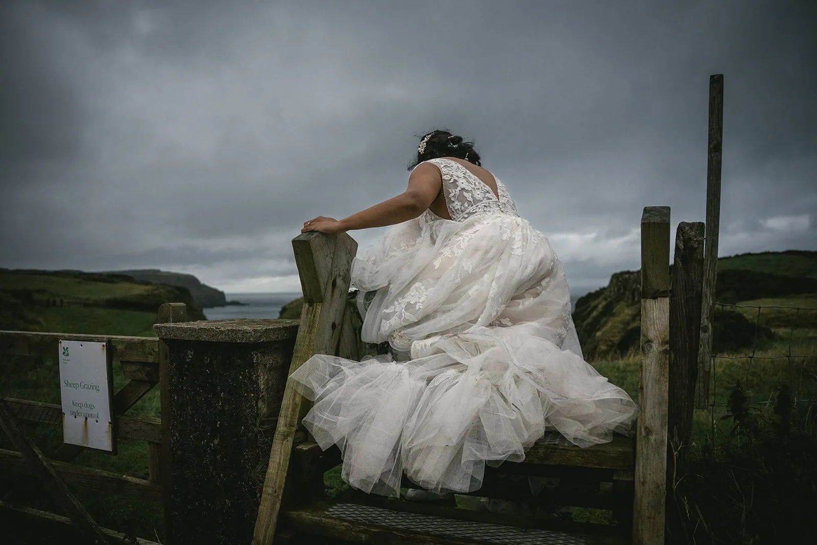 Bride's dress trailing behind her at Dunluce Castle during the elopement
