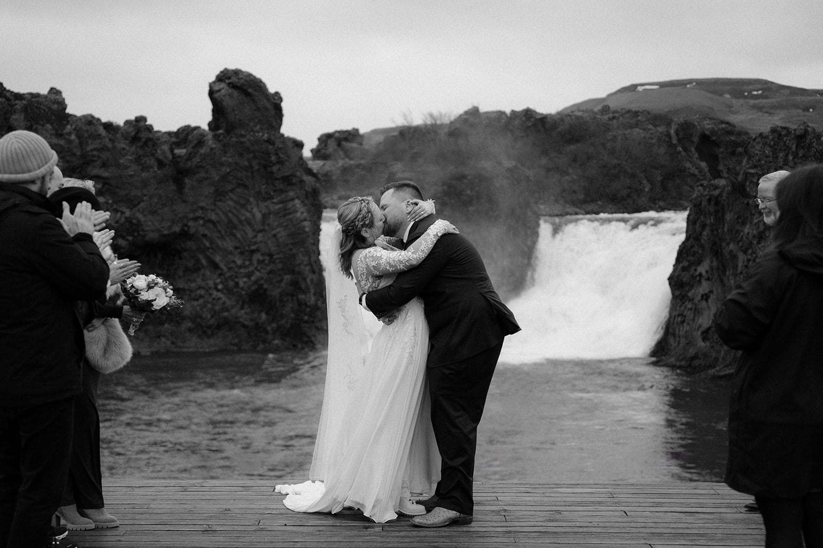 The couple’s first kiss by the waterfall during their Iceland elopement ceremony