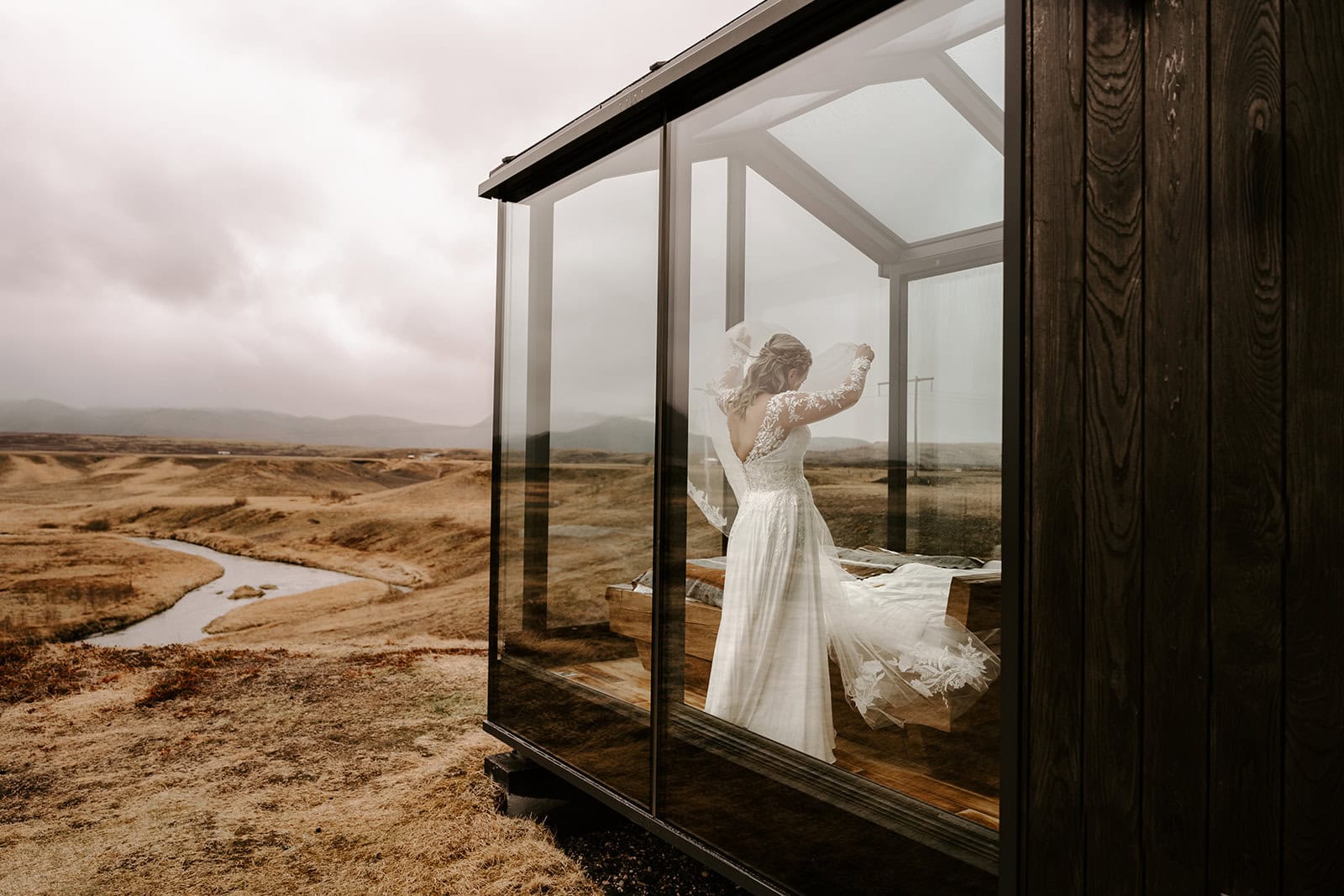 Bride in the lodge preparing her dress for an Icelandic elopement