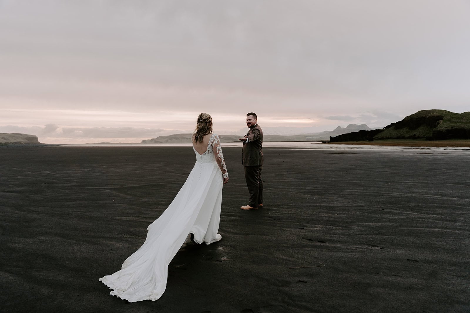 Romantic Iceland waterfall elopement, capturing the couple in front of a black sand beach