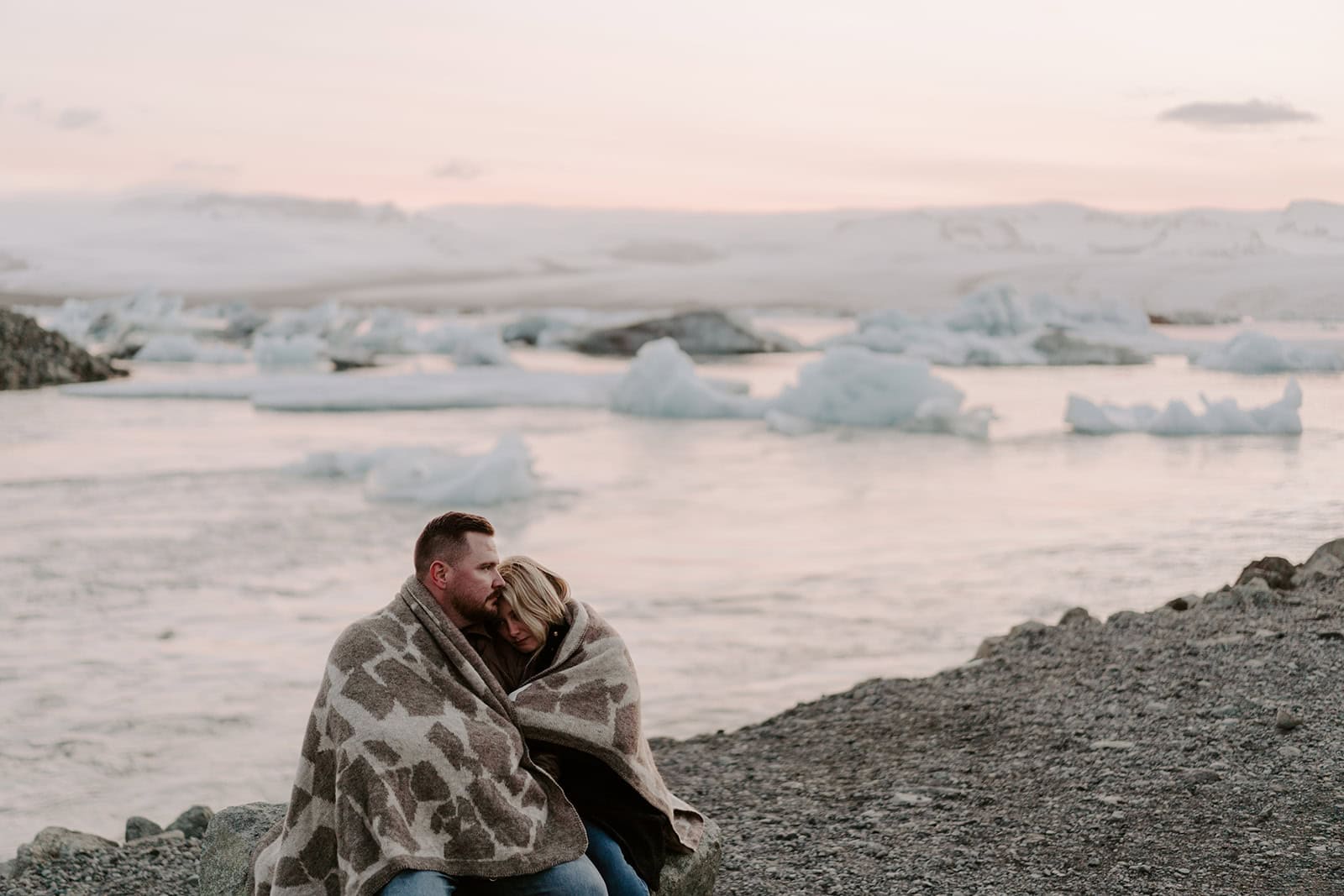 The sun shining on the couple as they stand by the glacier in Iceland