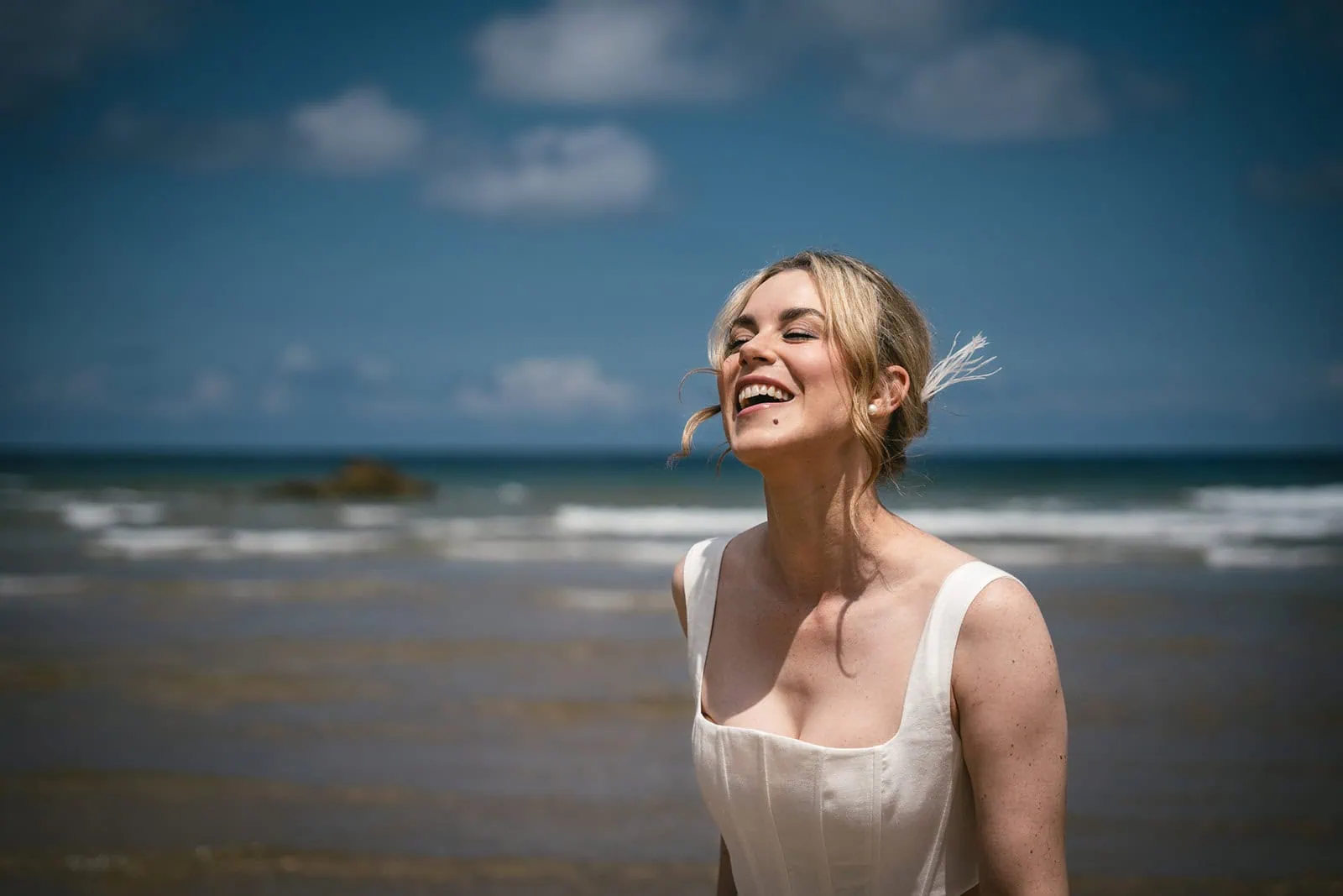 Bride laughing as they explore a secluded beach during their Spain elopement