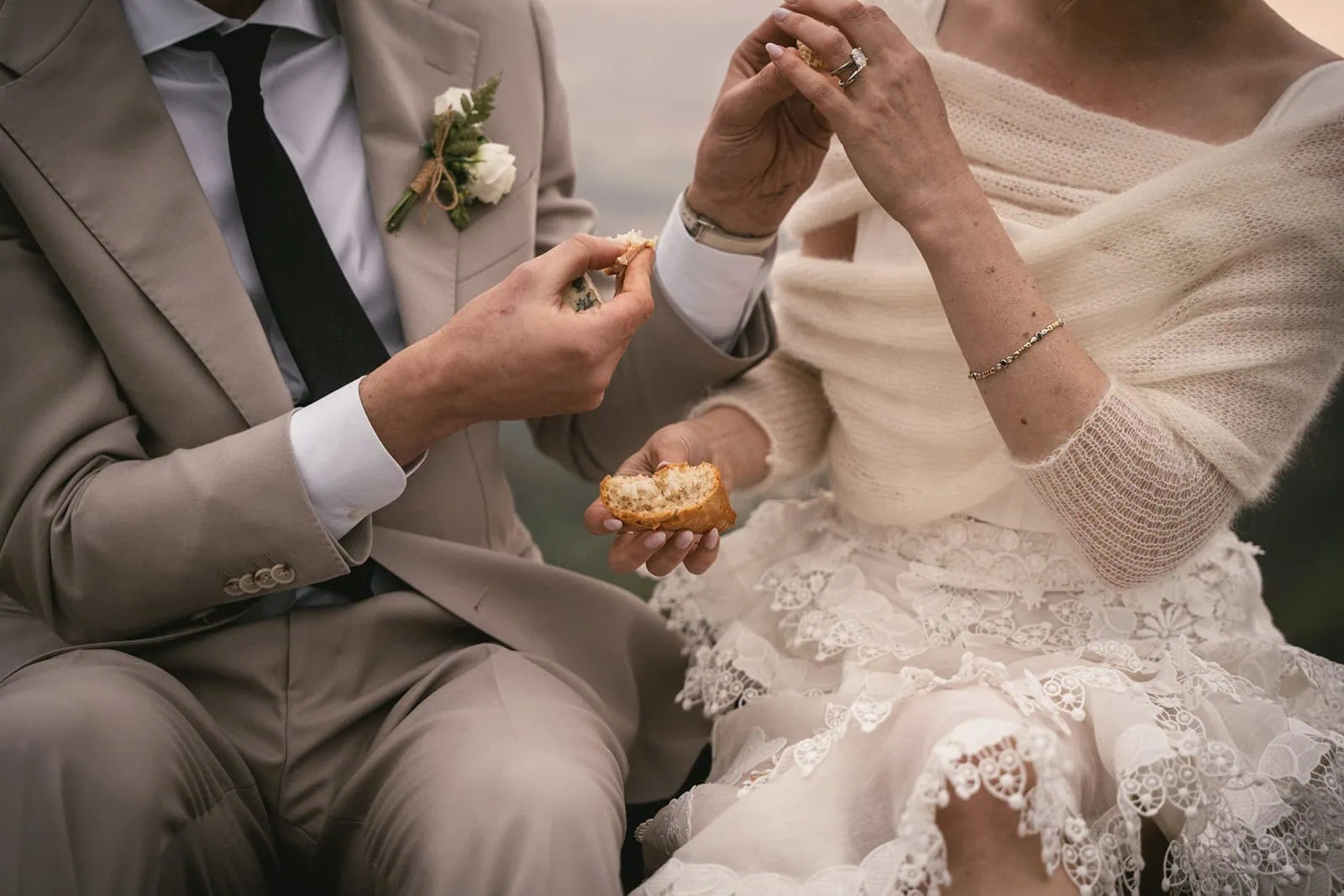 Bride and groom enjoying their picnic, framed by towering cliffs during their Asturias elopement adventure