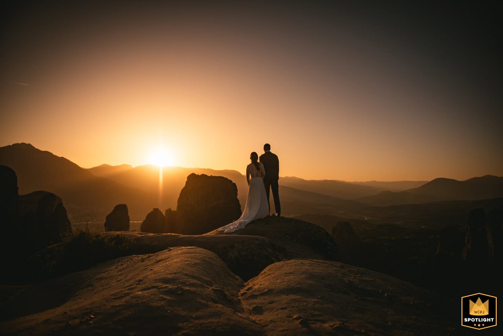 Couple silhouetted against golden sunset on volcanic rocks, showcasing the dramatic ceremony locations in our elopement packages in the Azores
