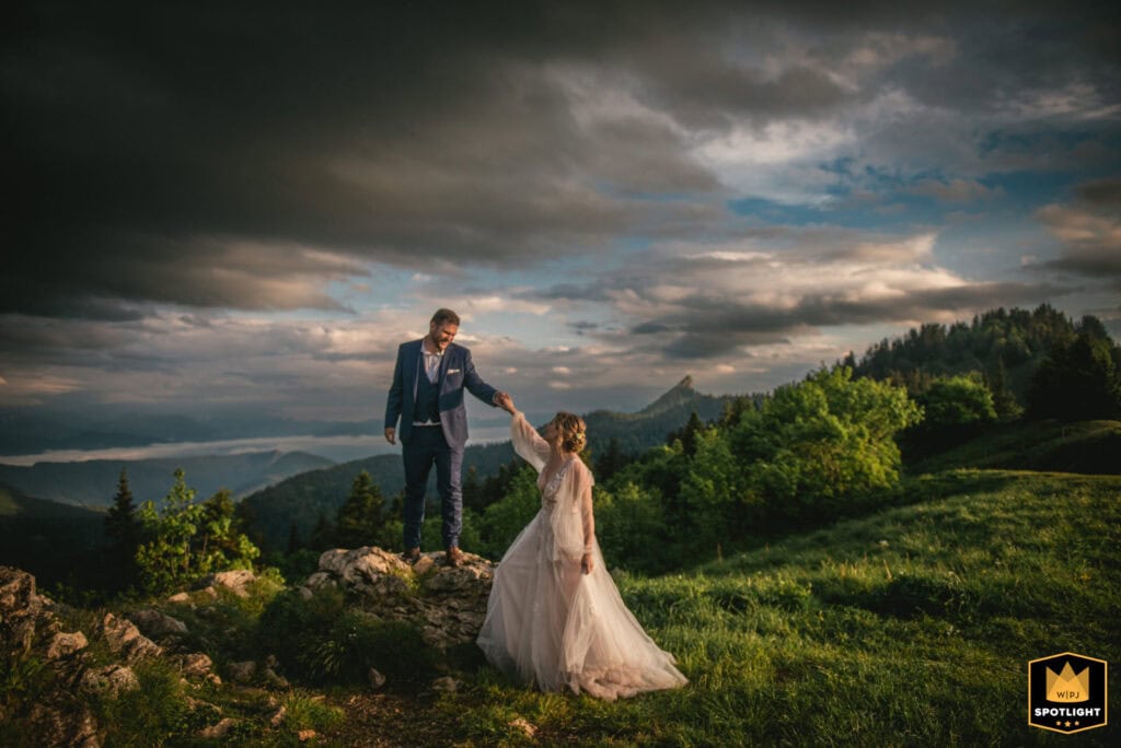Bride and groom on dramatic rock formation during golden Japanese mountain sunset, demonstrating the epic moments in our packages