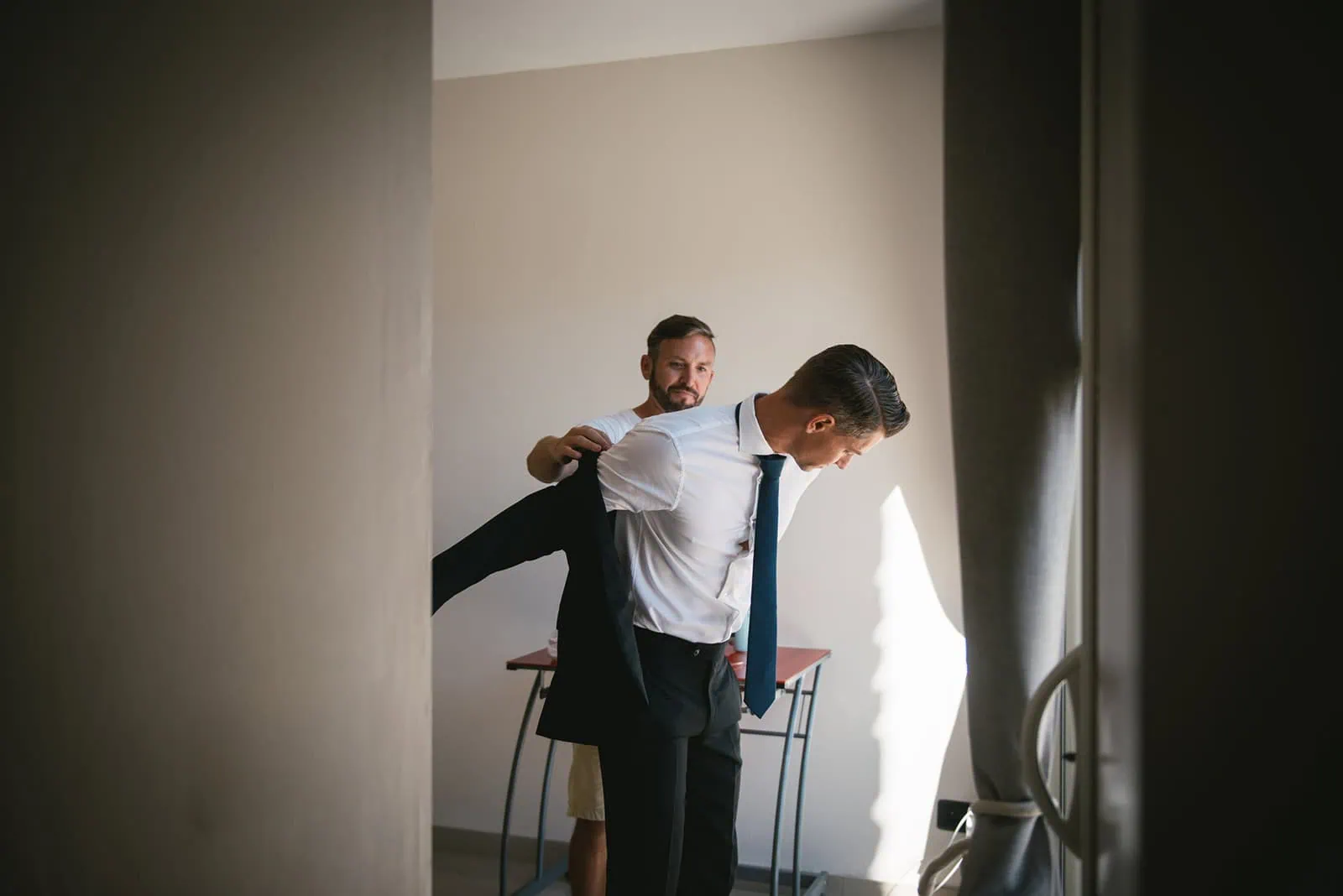 Witness helping the groom before the ceremony at this South of France elopement