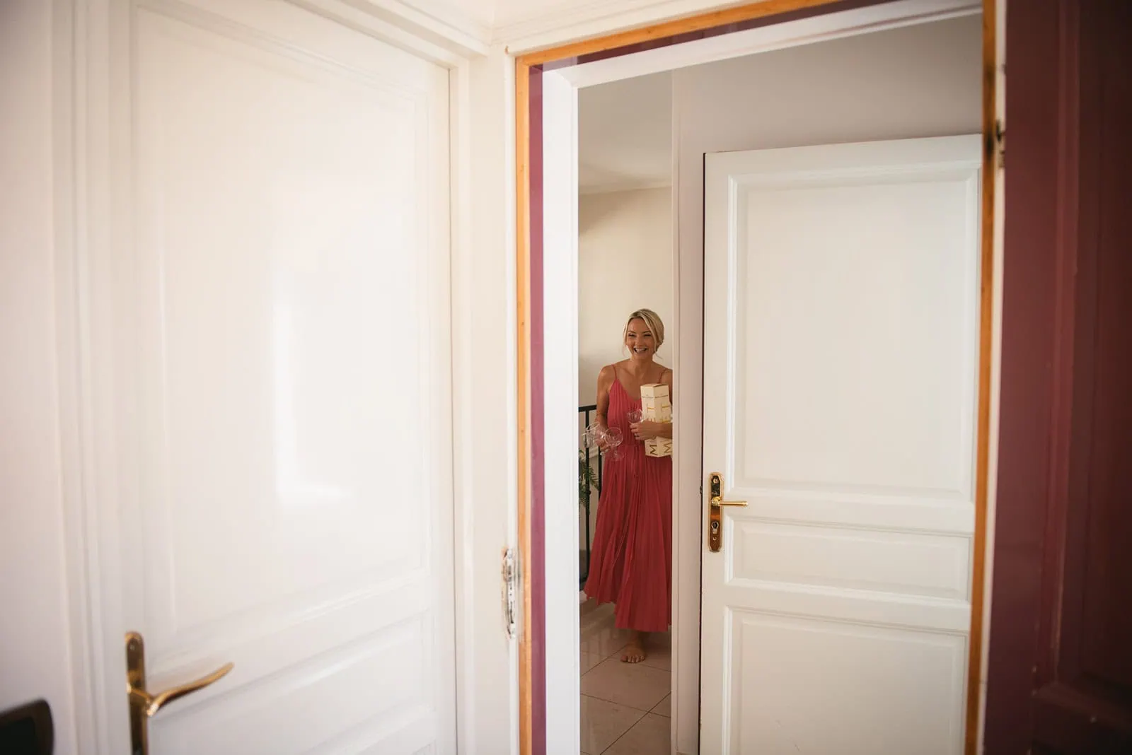 The bride coming to her room with a bottle a champagne to celebrate her South of France elopement