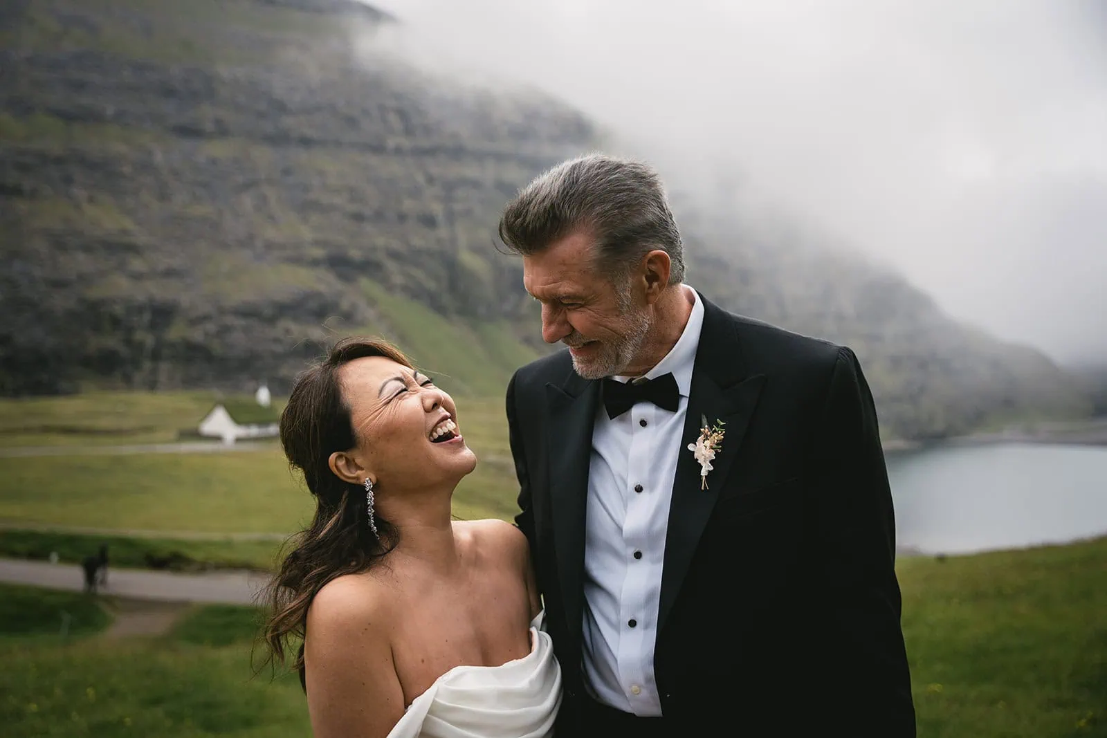 Bride laughing as the groom looks at her lovingly in a Torshavn elopement