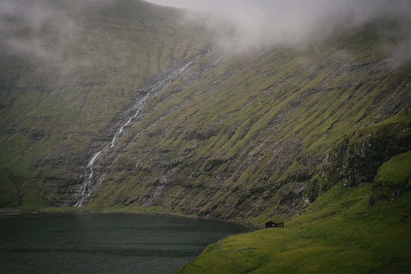 A stunning waterfall cascading in the background during this Torshavn elopement photoshoot