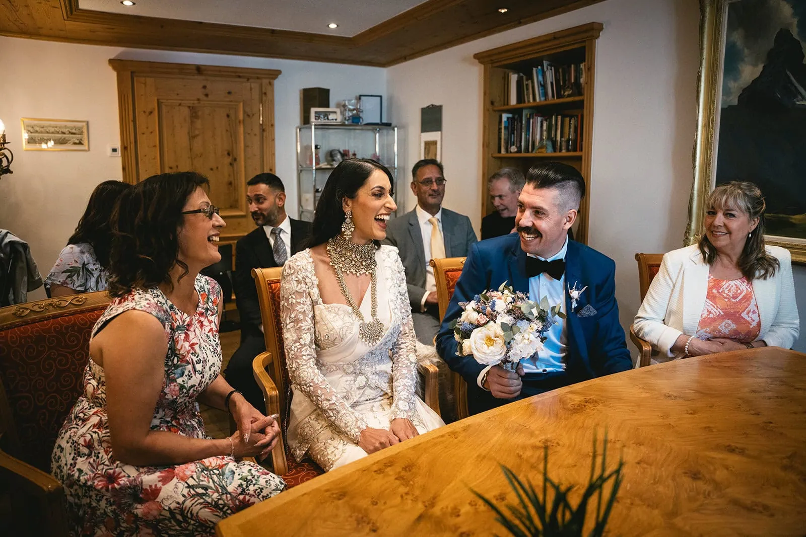 A laugh exchanged between the bride and groom as they prepare to sign the papers during their Zermatt elopement