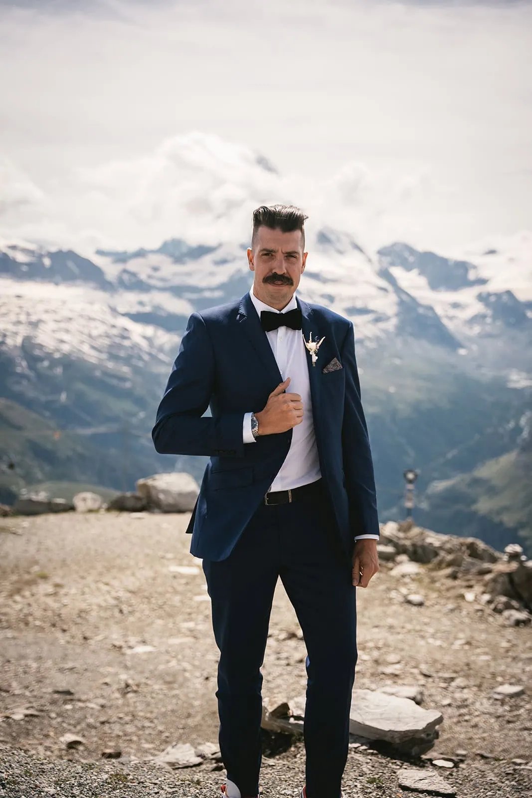 Portrait of the groom during his Zermatt elopement, with snowy mountains