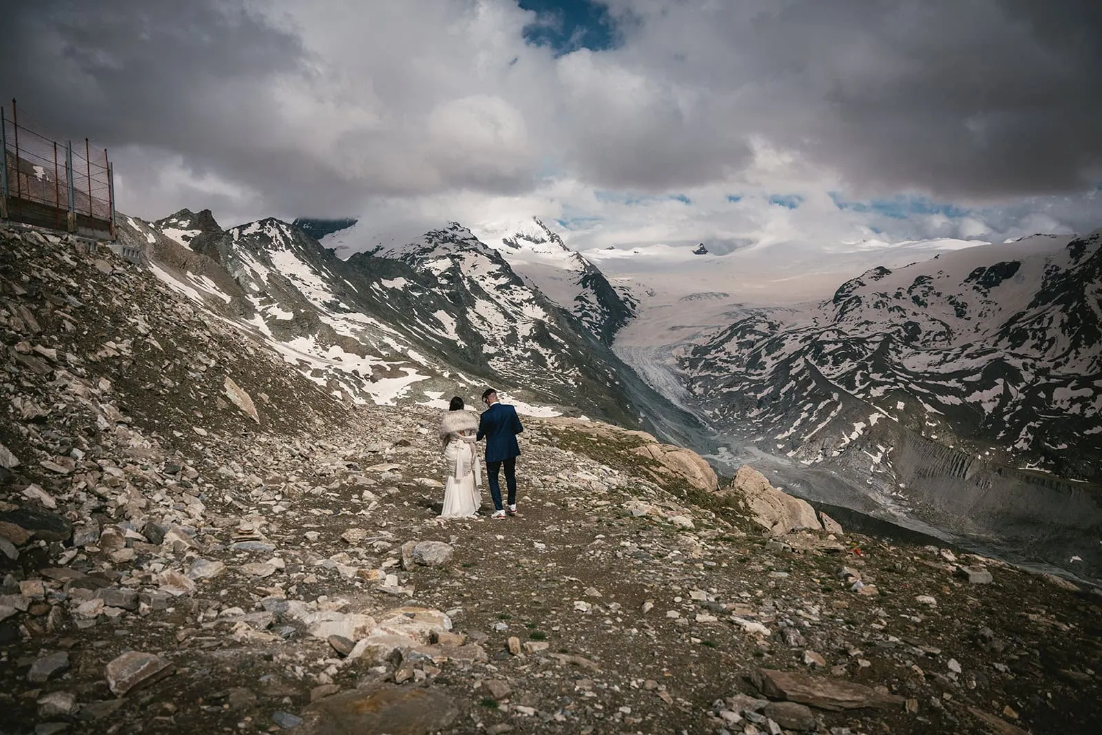 Bride and groom standing on a remote peak, soaking in the view during their Zermatt elopement