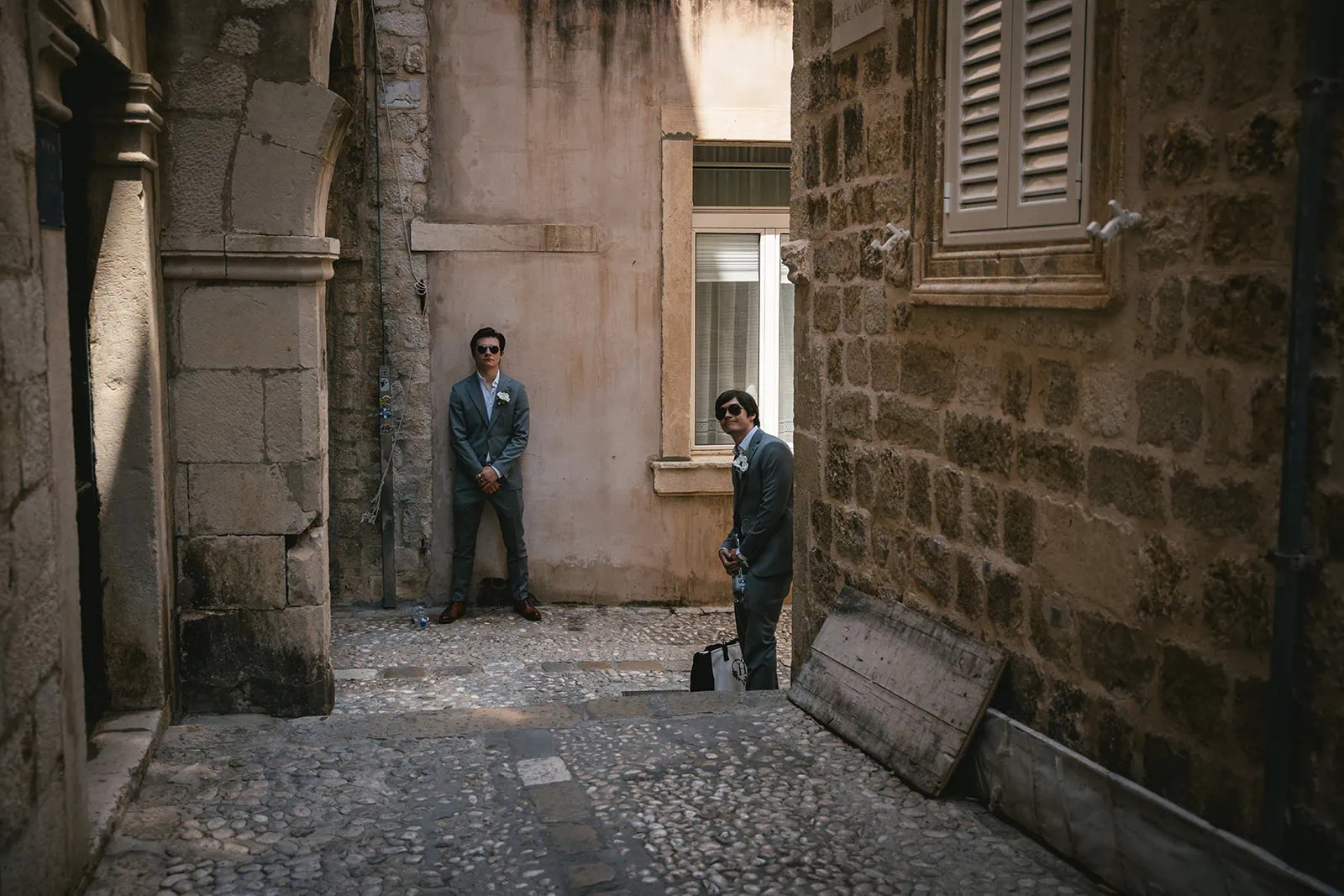 Bride and groom's sons posing in the ancient streets of Dubrovnik, during their parents' elopement in Croatia
