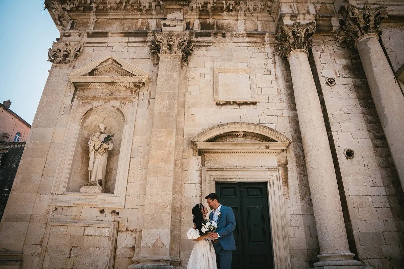Bride and groom walking along ancient city walls during their Dubrovnik elopement