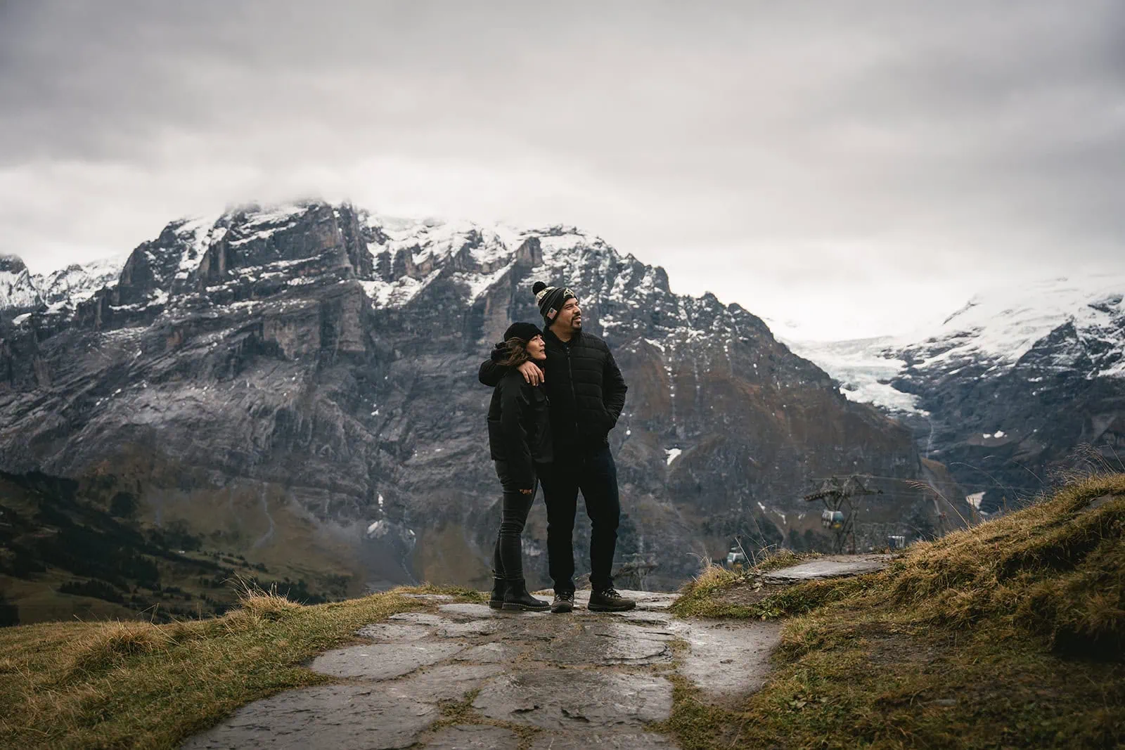 Groom holding his bride close as the snow peaks loom in the background of their Gornergrat elopement