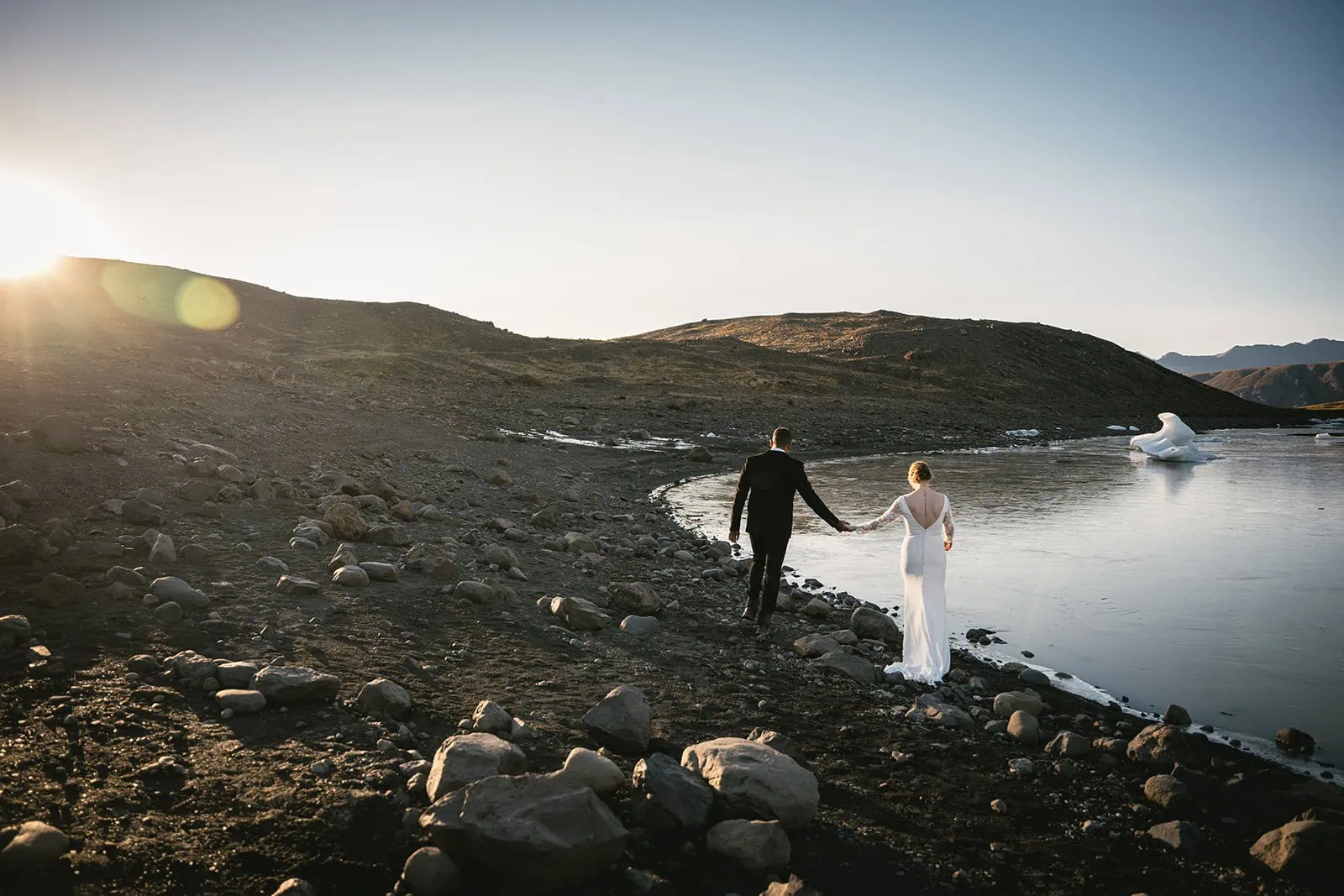 Walking by the glacier lake in their Hofn elopement