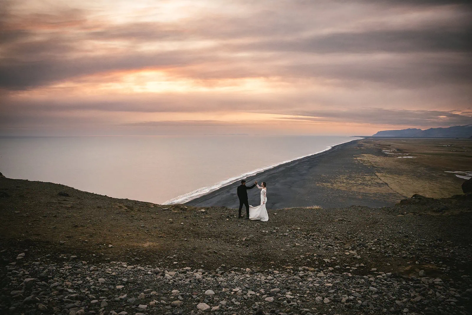 Quiet moment as they dancing at golden hour on a cliff, last shoot of a stunning Hofn elopement in Iceland