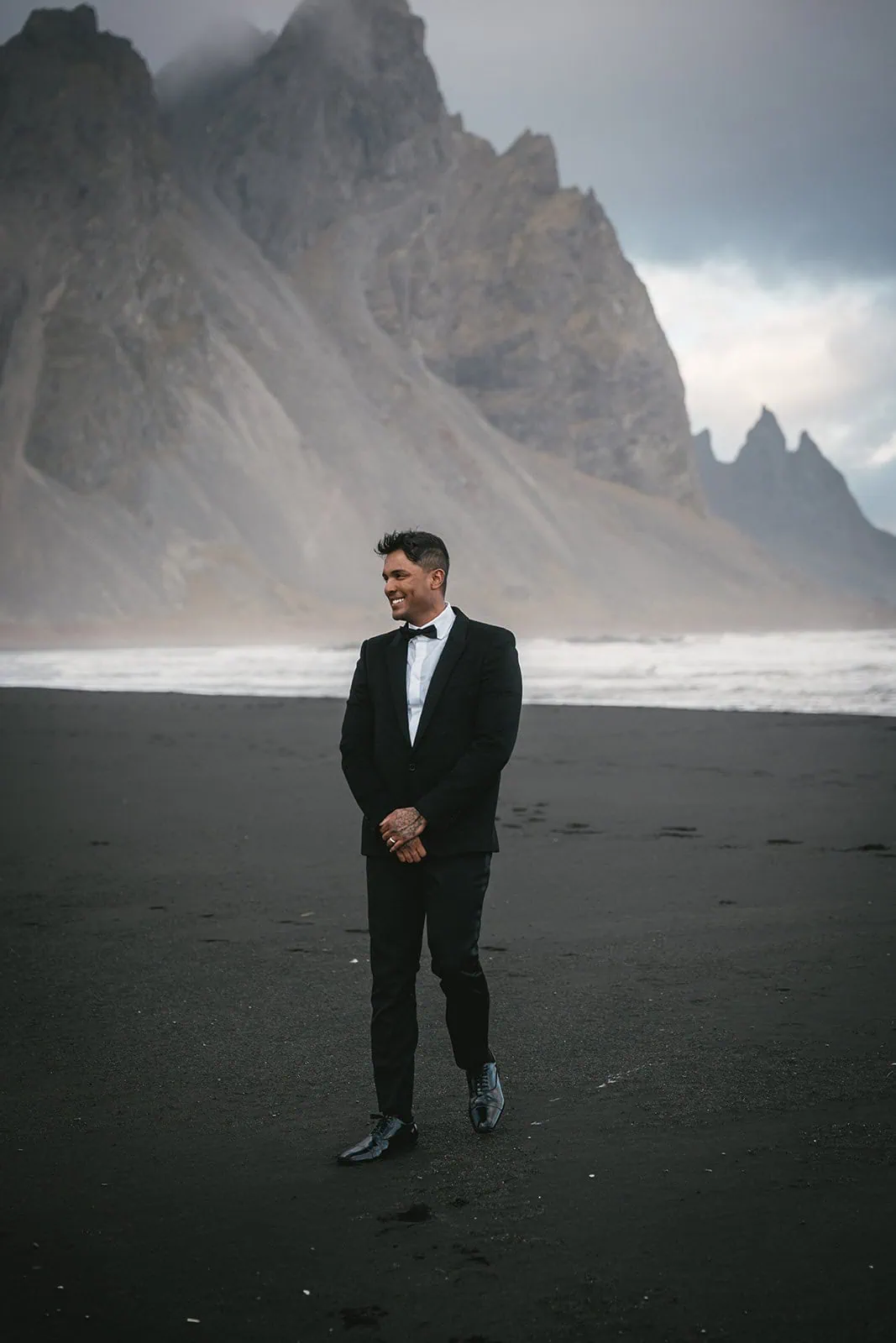 Portrait of the groom on a black sand beach during a Hofn elopement