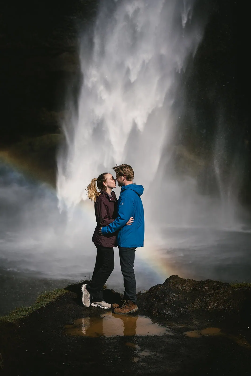 Tender moment by a waterfall and rainbox in a Reynisfjara elopement in Iceland