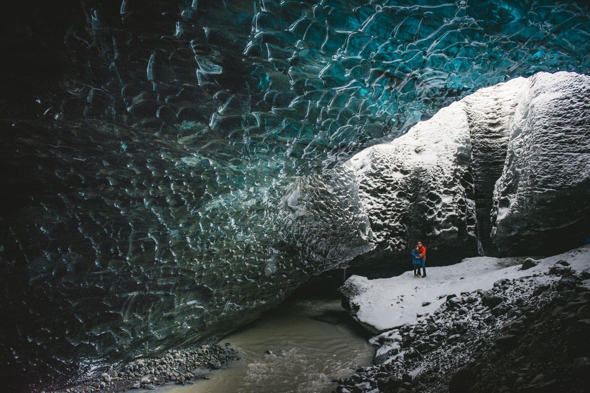 Couple eloping inside a glowing blue Icelandic ice cave