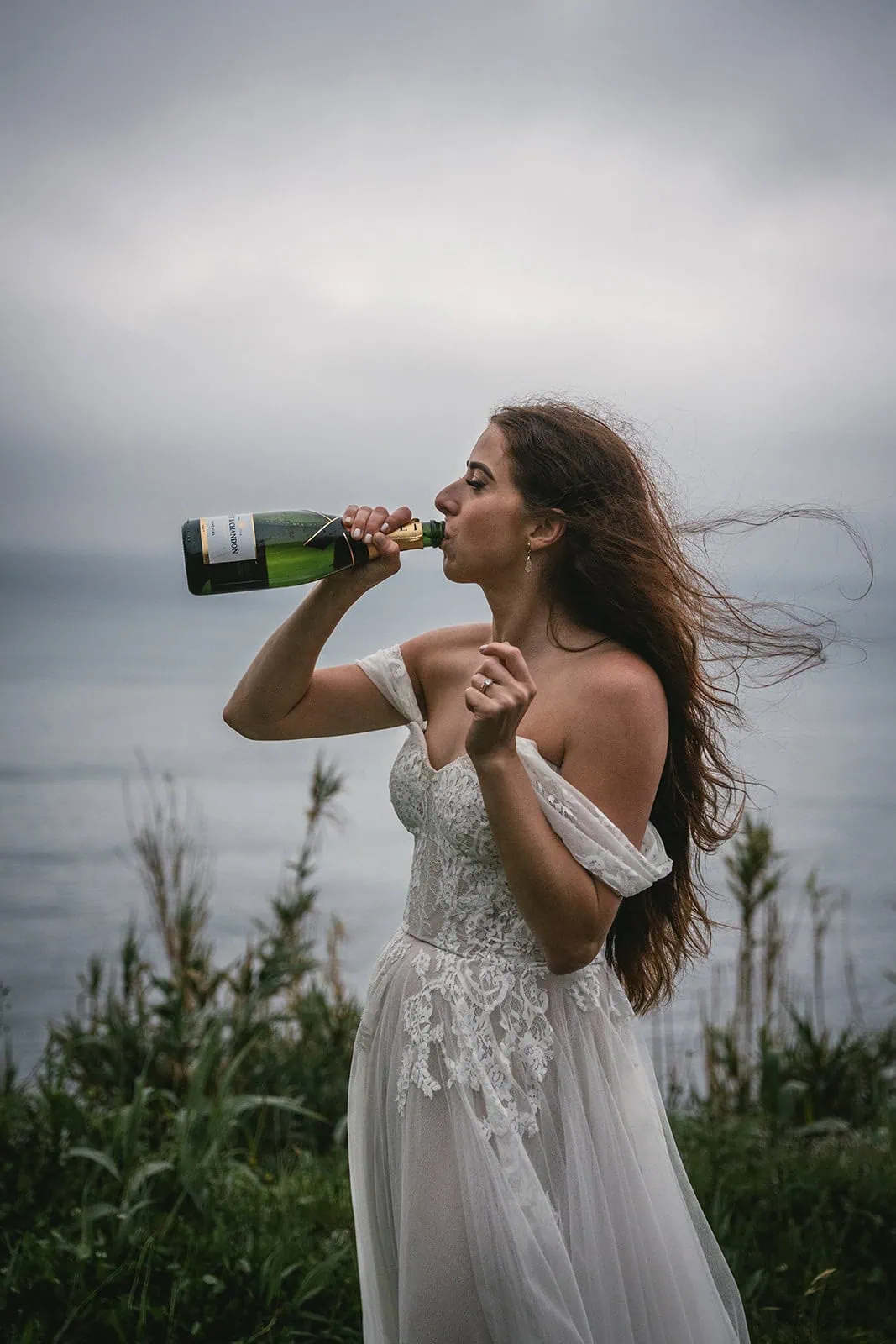 Bride celebrating her Ponta Delgada elopement with champagne by the ocean