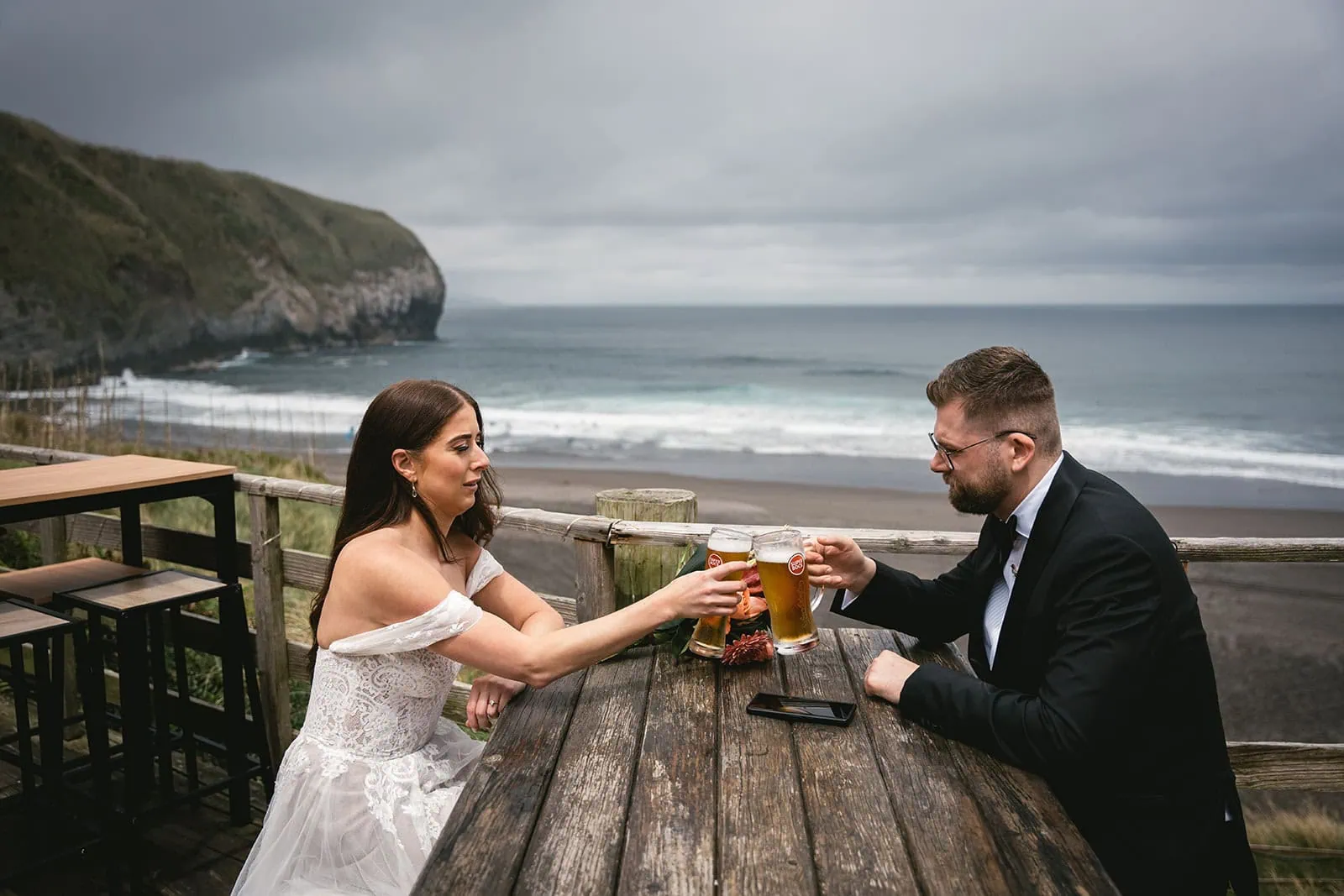 Taking a break during their Ponta Delgada elopement in front of the ocean