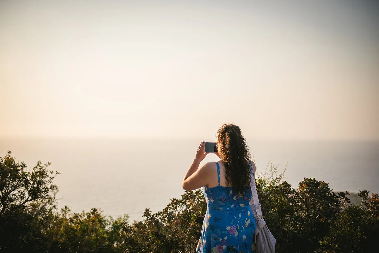 Guest capturing the view above the ocean before the ceremony of this Rhodes Island elopement