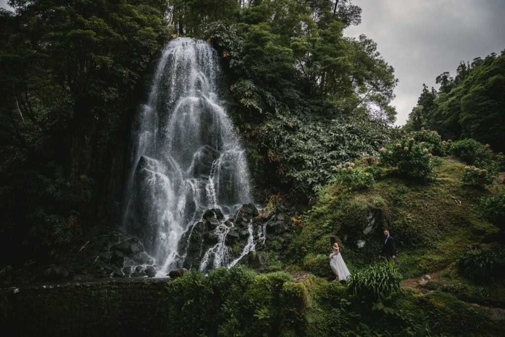 Stunning waterfall backdrop with a bride and groom in a romantic outdoor wedding.