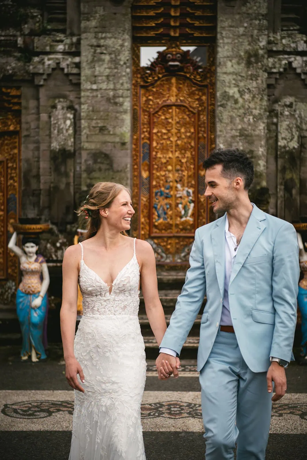 Couple gazing at each ohter by the temple wall after their Bali elopement vows