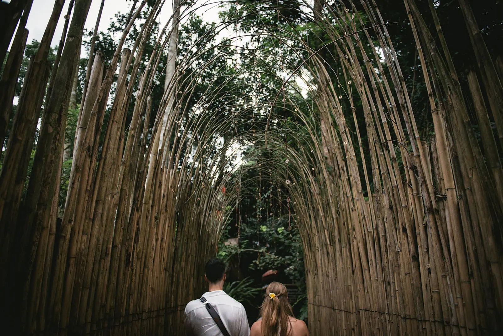 Walking hand in hand across a bamboo groove during a Bali elopement adventure